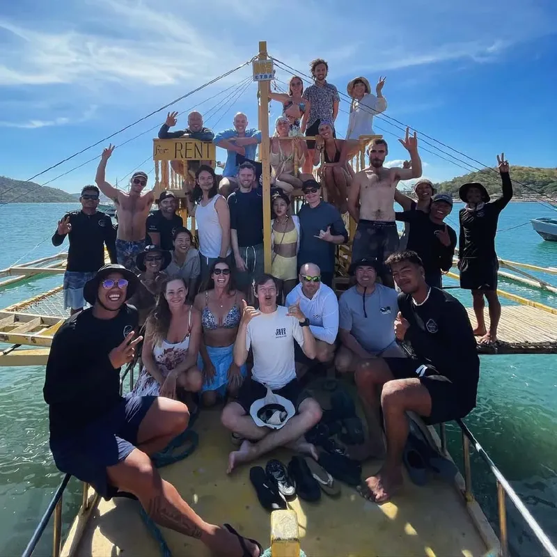 Groupe de personnes souriantes sur un bateau en mer, ambiance joyeuse