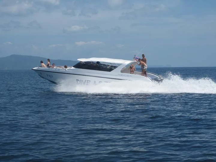 Speedboat blanc naviguant sur une mer bleue avec des passagers