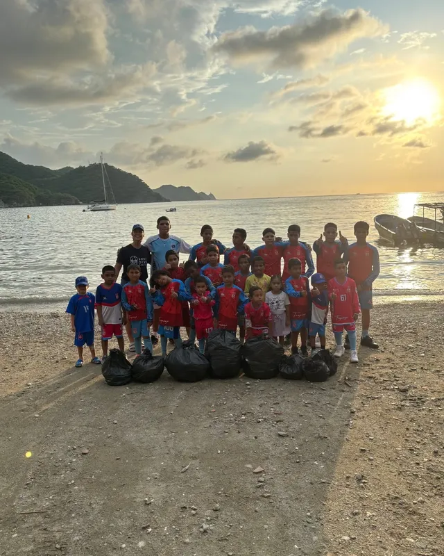 Groupe d'enfants et d'adultes sur une plage au coucher du soleil