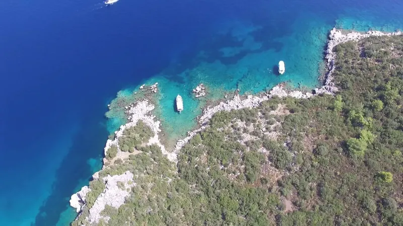 Vue aérienne de bateaux ancrés dans une crique turquoise rocheuse