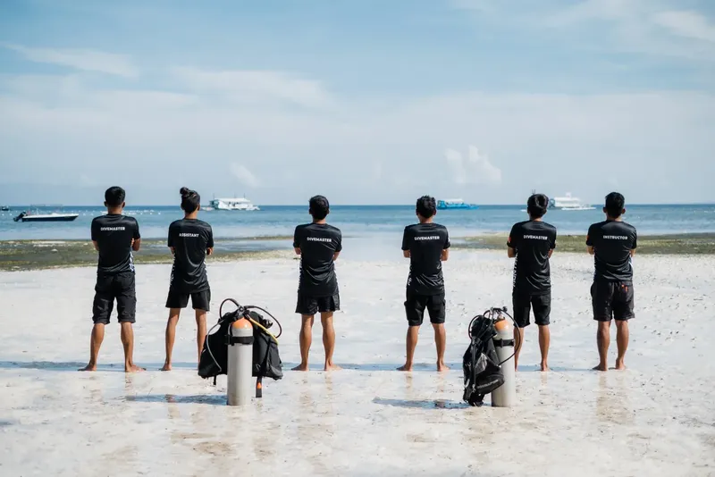 Groupe de personnes regardant la mer avec du matériel de plongée