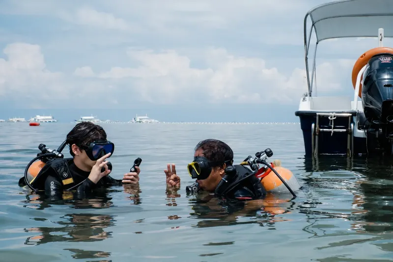 Deux plongeurs en surface discutent, équipés et prêts à explorer
