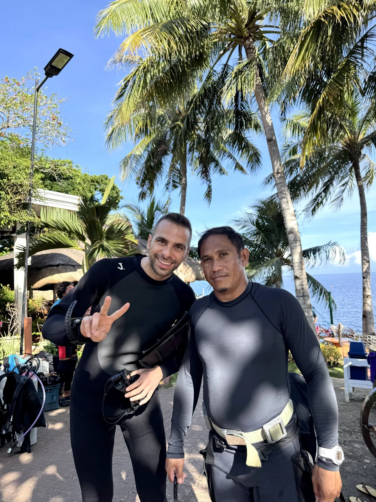 Deux hommes souriants en combinaison de plongée près du matériel