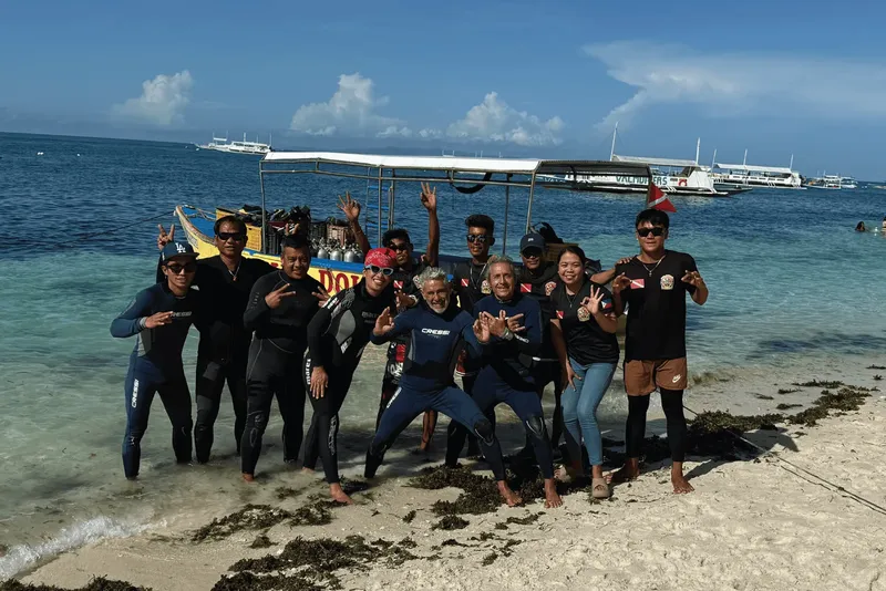 Groupe de plongeurs souriants sur une plage tropicale ensoleillée