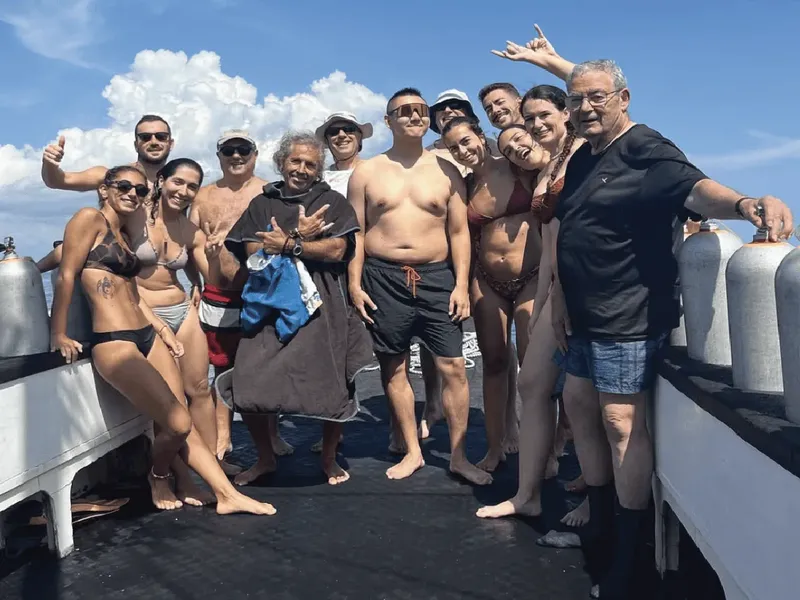 Groupe de plongeurs souriants sur le pont d'un bateau en mer