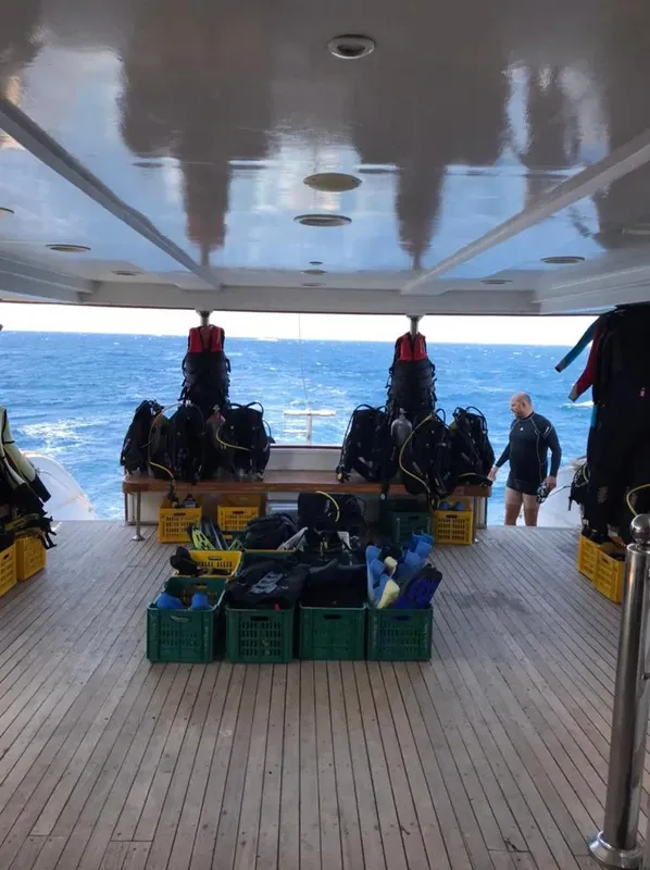 Terrasse d'un bateau de plongée avec équipement et une personne