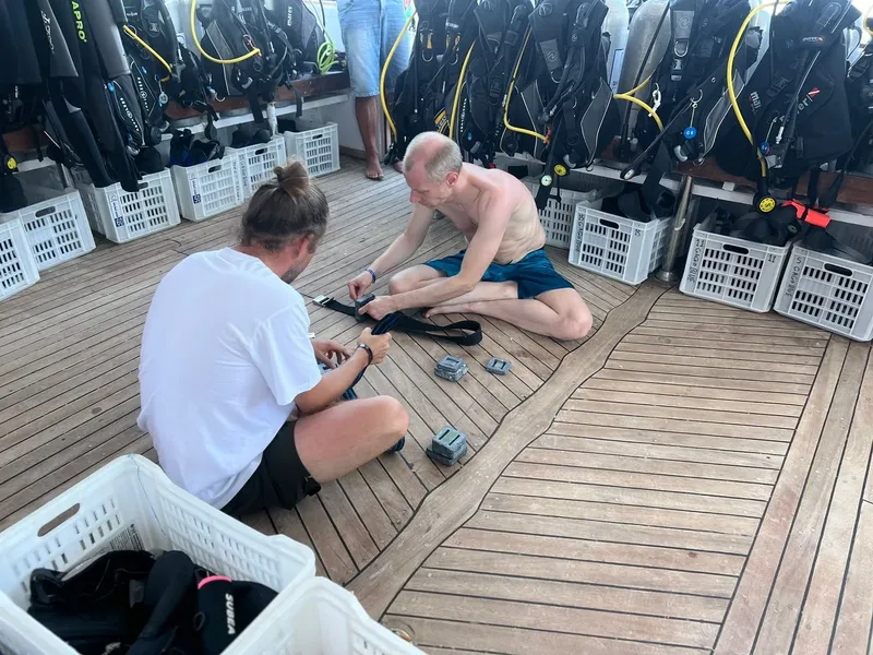 Deux plongeurs préparent leur équipement sur le pont d'un bateau