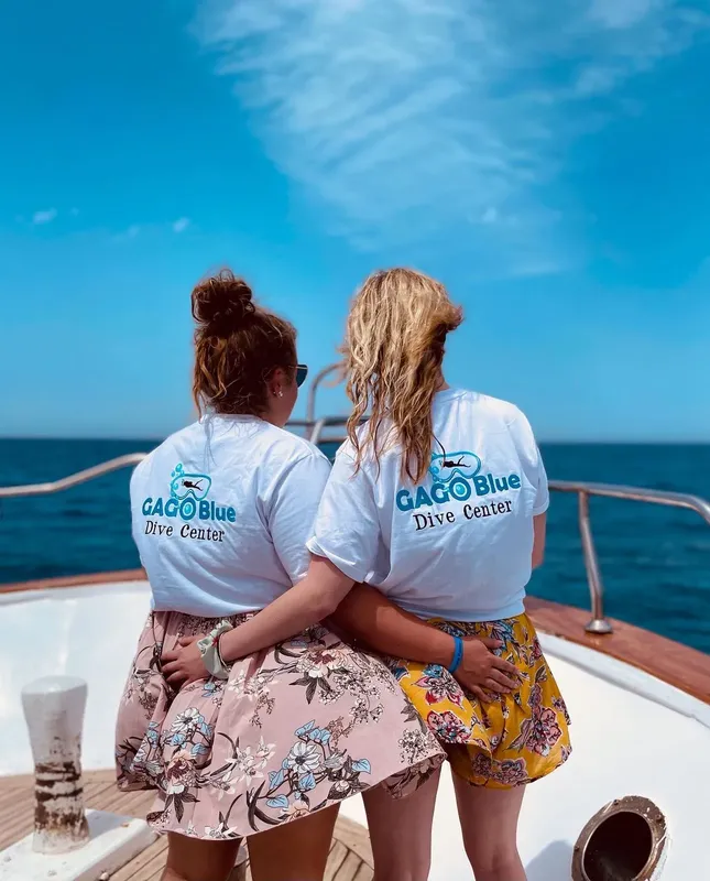 Deux femmes regardent l'horizon depuis le pont d'un bateau de plongée