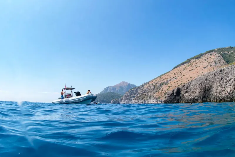 Bateau de plongée en mer avec des personnes à bord et paysage