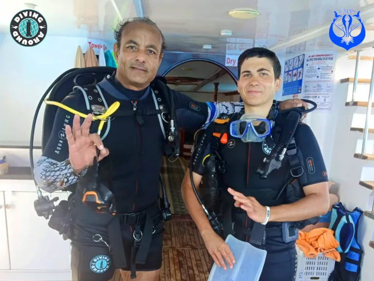 Deux plongeurs souriants équipés de gilets et de détendeurs à bord