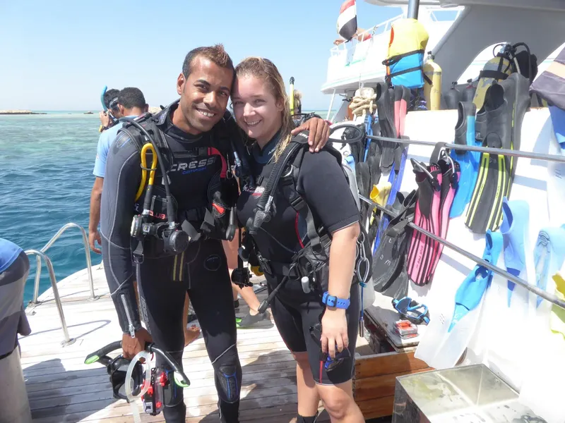Deux plongeurs souriants sur un bateau avec leur équipement complet