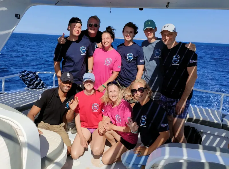 Groupe de personnes souriantes sur un bateau en mer, journée ensoleillée