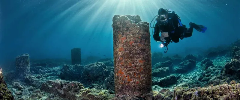 Plongeur explorant des ruines antiques sous-marines avec une lumière