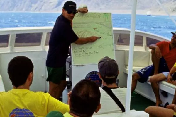 Instructeur expliquant un plan de site de plongée à des participants