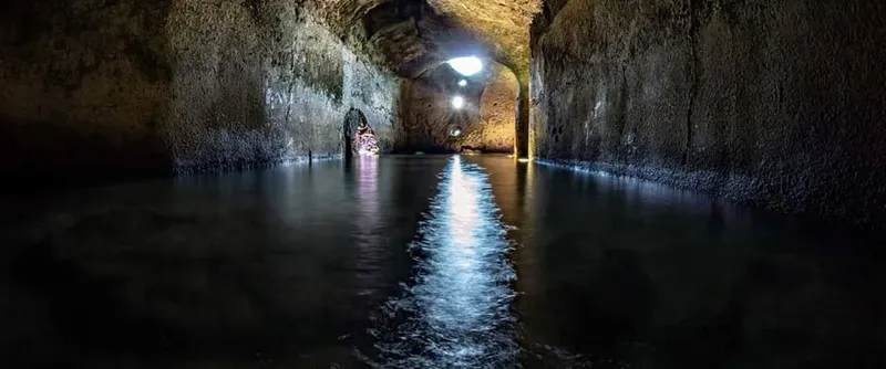 Tunnel sous-marin éclairé, vue plongeante, eau sombre et claire