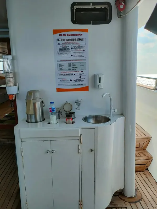 Plan de travail avec cafetière, évier et instructions de sécurité sur bateau