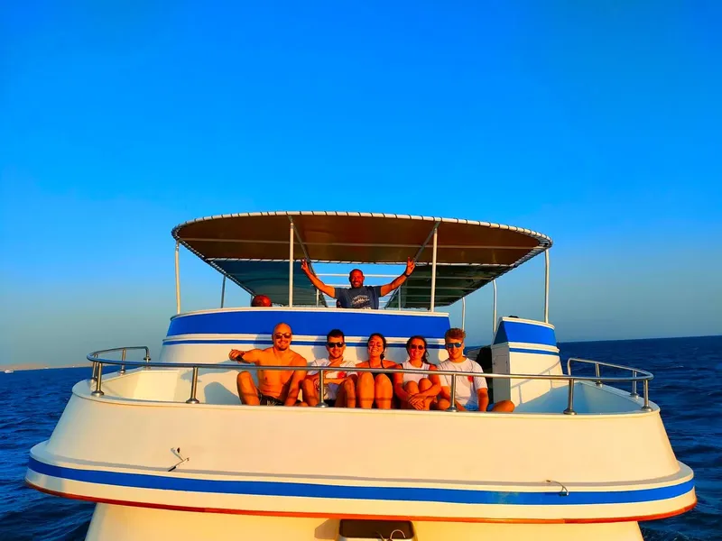 Groupe de personnes souriantes sur le pont d'un bateau de plongée