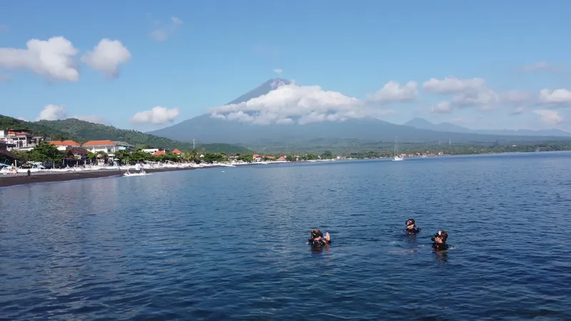 Groupe de plongeurs en surface avec vue sur un volcan et la côte
