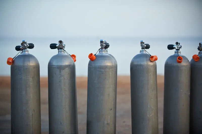 Rangée de bouteilles de plongée en aluminium avec bouchons orange
