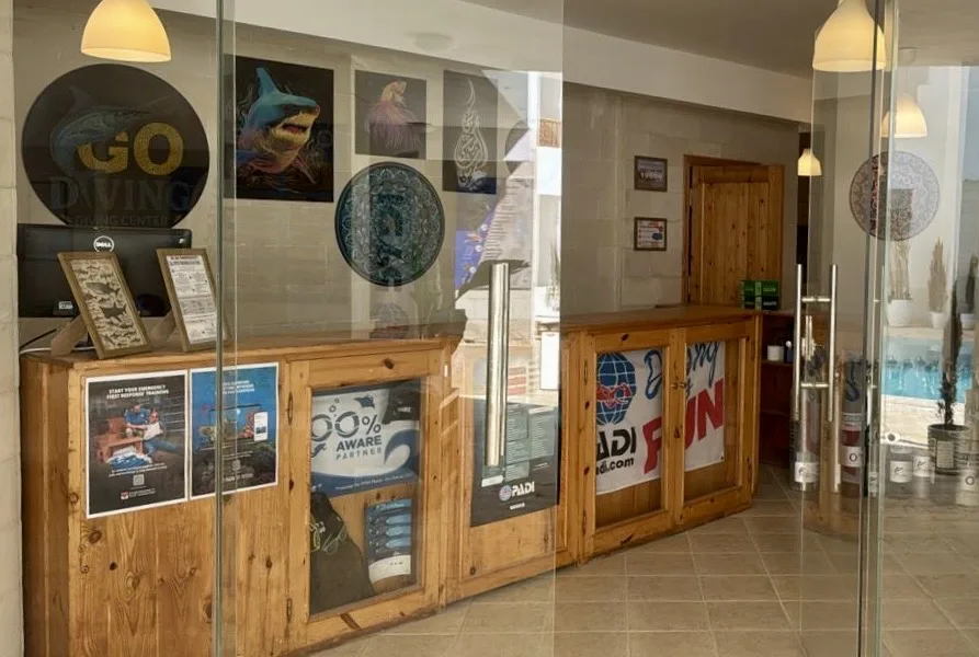 Reception d'un centre de plongee avec comptoir en bois et affiches