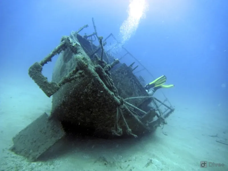 Plongeur explorant l'épave d'un bateau coulé sur fond sableux