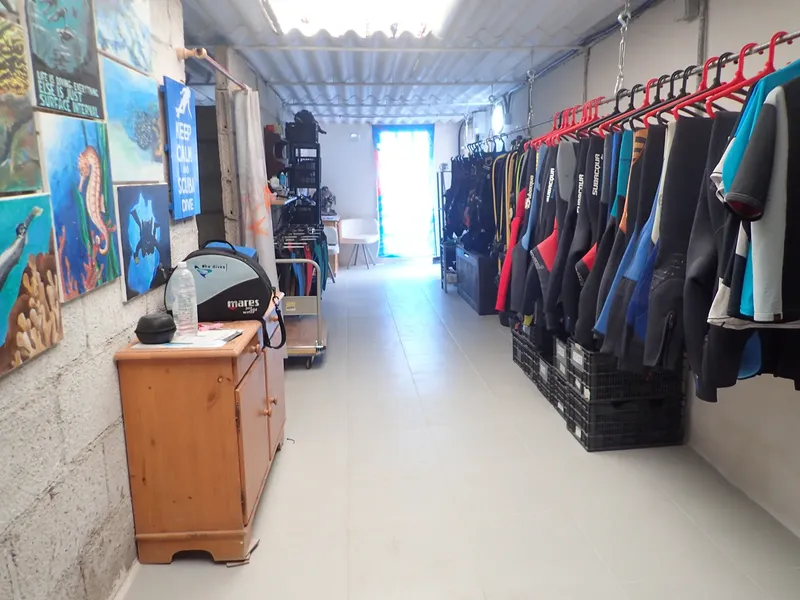 Intérieur d'un centre de plongée avec combinaisons et matériel visible