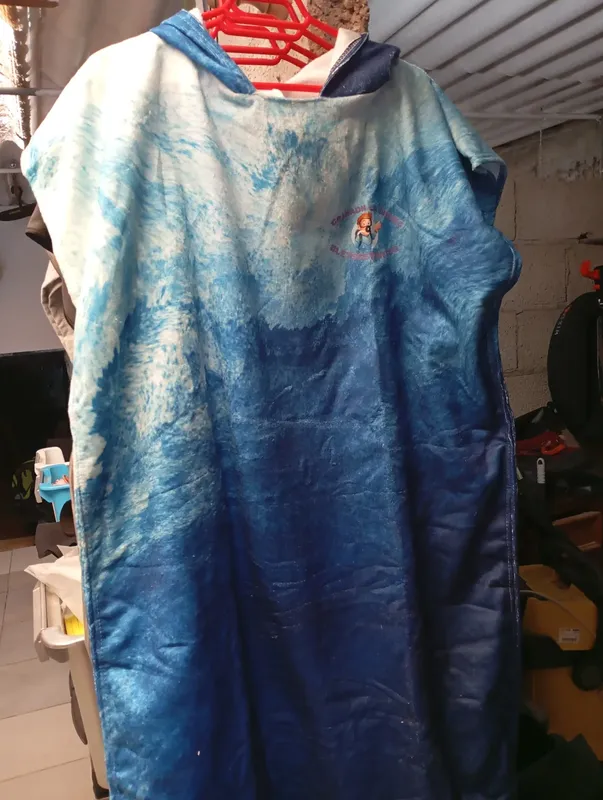 Peignoir de plongée bleu et blanc suspendu sur un cintre rouge