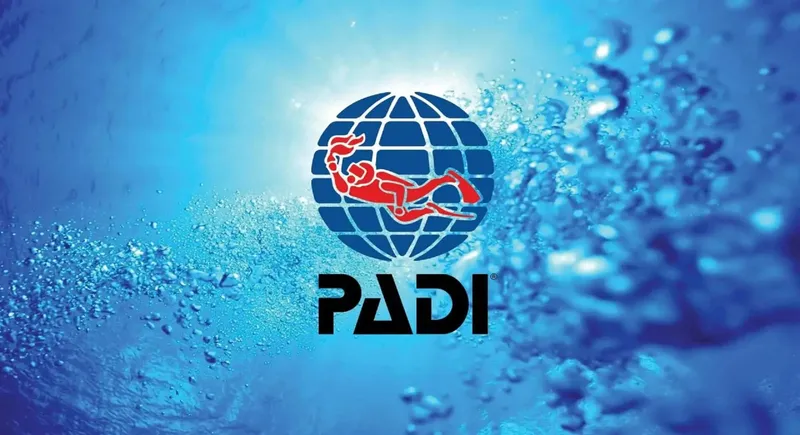 Logo PADI avec un plongeur sur un globe, fond bleu bulles