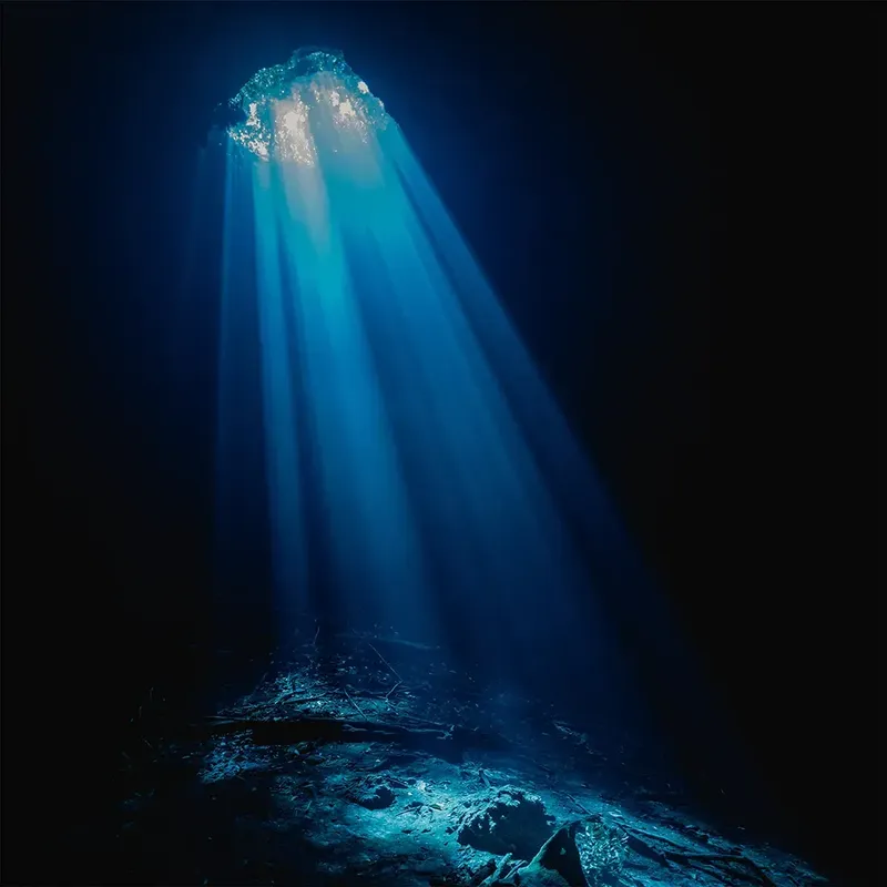 Rayons de lumière perçant l'eau d'une grotte sous-marine profonde