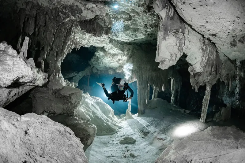 Plongeur explore une grotte sous-marine illuminée par un rayon de lumière