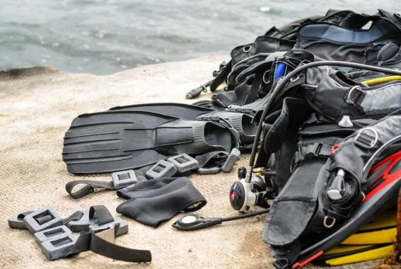 Equipement de plongée étalé sur du sable près de l'eau