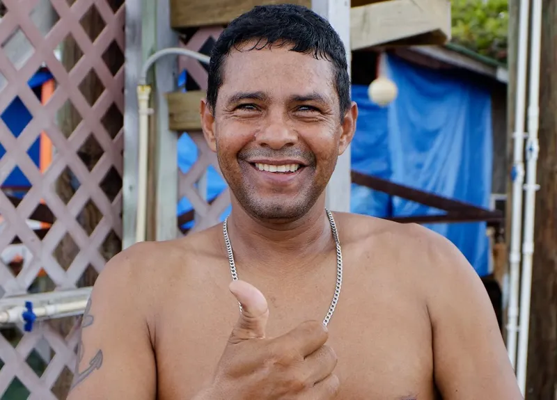Homme souriant torse nu, pouce levé, regardant la caméra avec joie