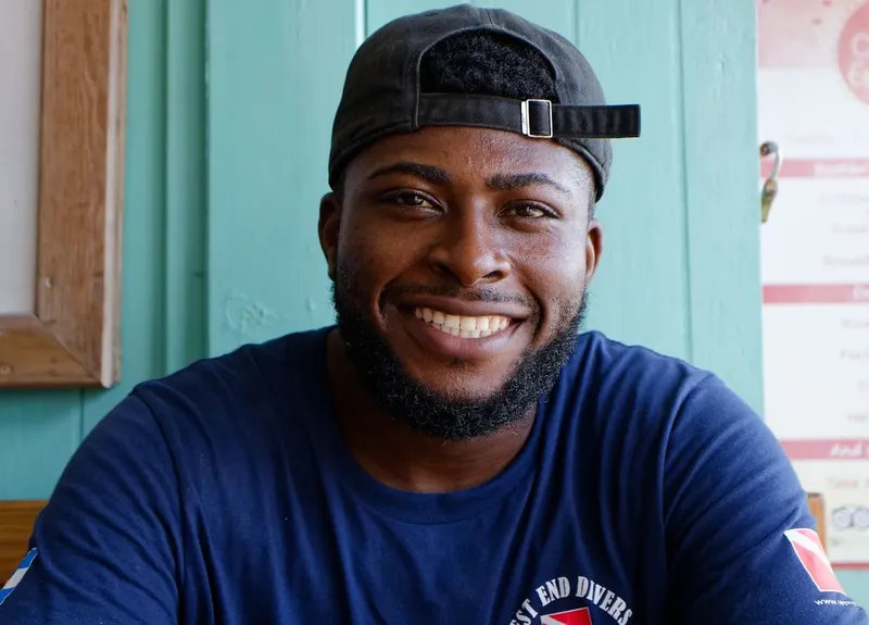 Portrait souriant d'un homme portant un t-shirt avec un logo