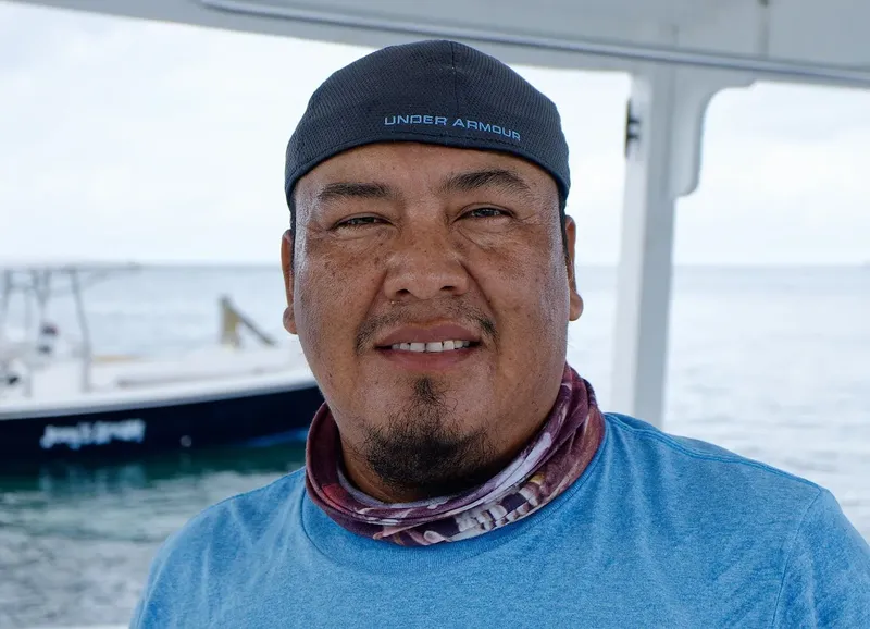 Homme souriant portant une casquette et un tour de cou coloré