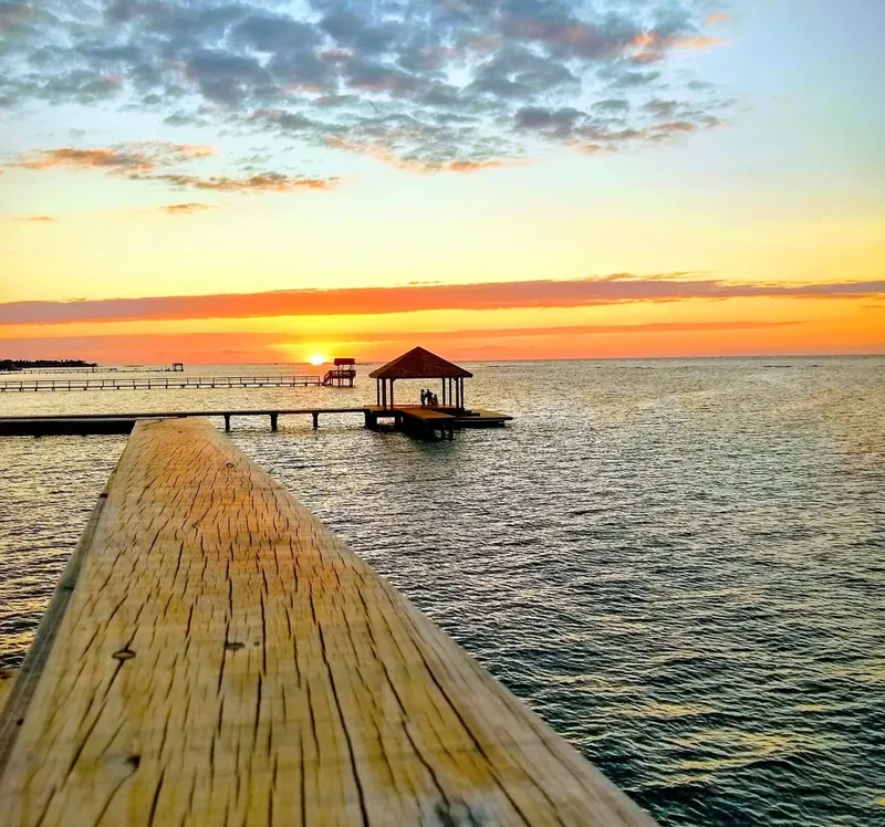 Coucher de soleil sur l'océan avec ponton en bois et personnes