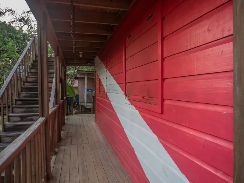 Façade d'un bâtiment rouge et blanc avec un escalier en bois