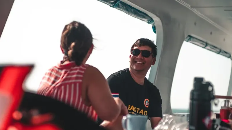 Deux personnes sourient et discutent à bord d'un bateau de plongée