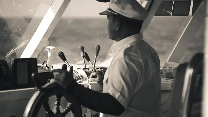 Capitaine tenant la barre d'un bateau en haute mer