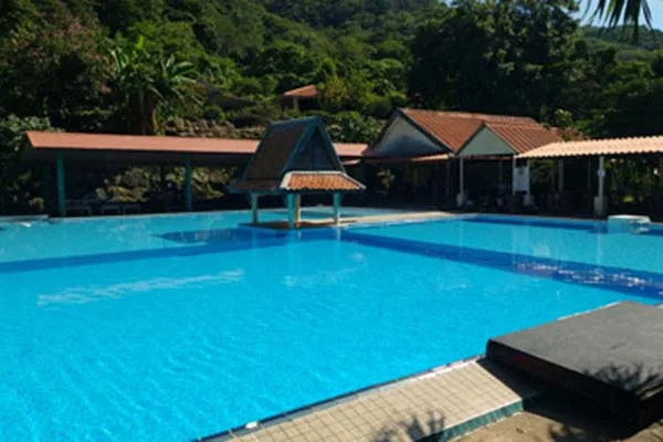 Bâtiments avec toits rouges au bord d'une piscine turquoise
