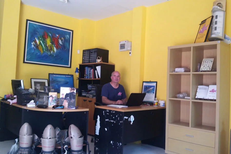 Bureau d'accueil avec un homme travaillant sur un ordinateur portable