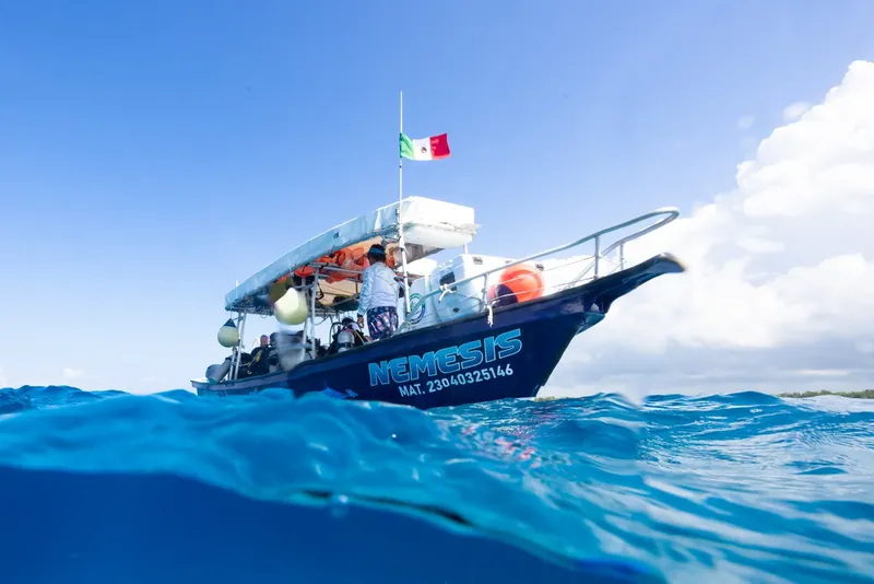 Bateau de plongée sur l'eau bleue avec des personnes à bord