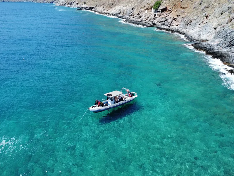 Bateau de plongee avec des passagers naviguant sur une eau turquoise claire