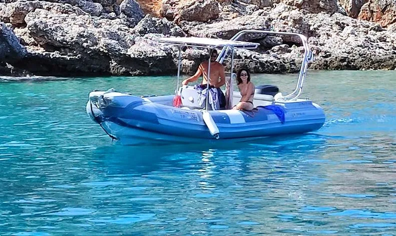 Deux personnes à bord d'un semi-rigide en mer turquoise