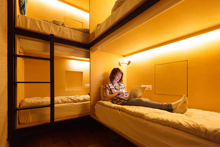 Jeune femme utilise un ordinateur portable dans un dortoir lumineux