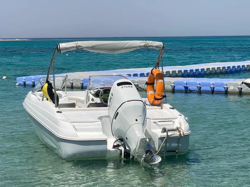Bateau de plongée blanc amarré à un ponton dans une eau turquoise