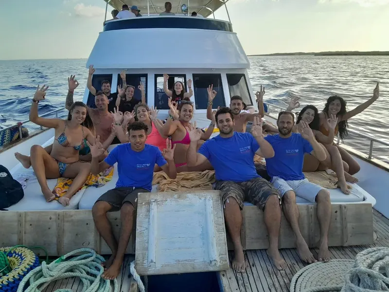 Groupe de personnes souriantes sur le pont d'un bateau de plongée