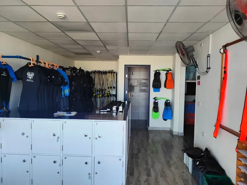 Intérieur d'un centre de plongée avec vestiaires, combinaisons et matériel
