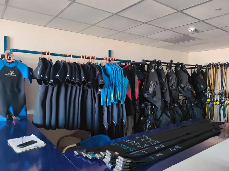 Rangées de combinaisons de plongée et d'équipements dans un local intérieur