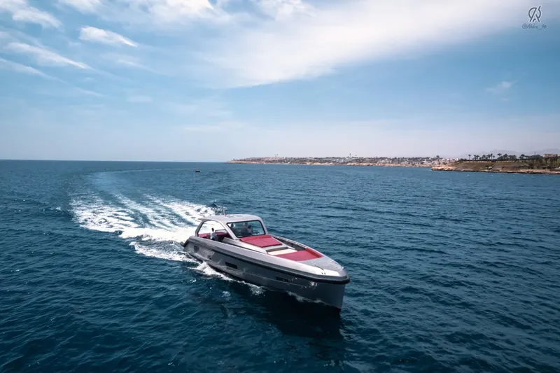 Bateau rapide gris et rouge navigue sur une mer bleue calme