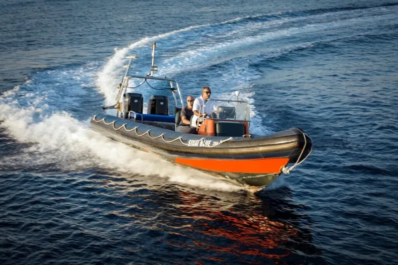 Bateau semi-rigide navigue sur une mer bleue avec des passagers